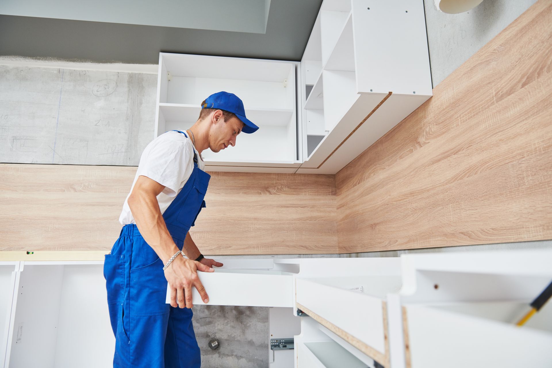 A skilled handyman assembling a cabinet as part of a kitchen installation project.