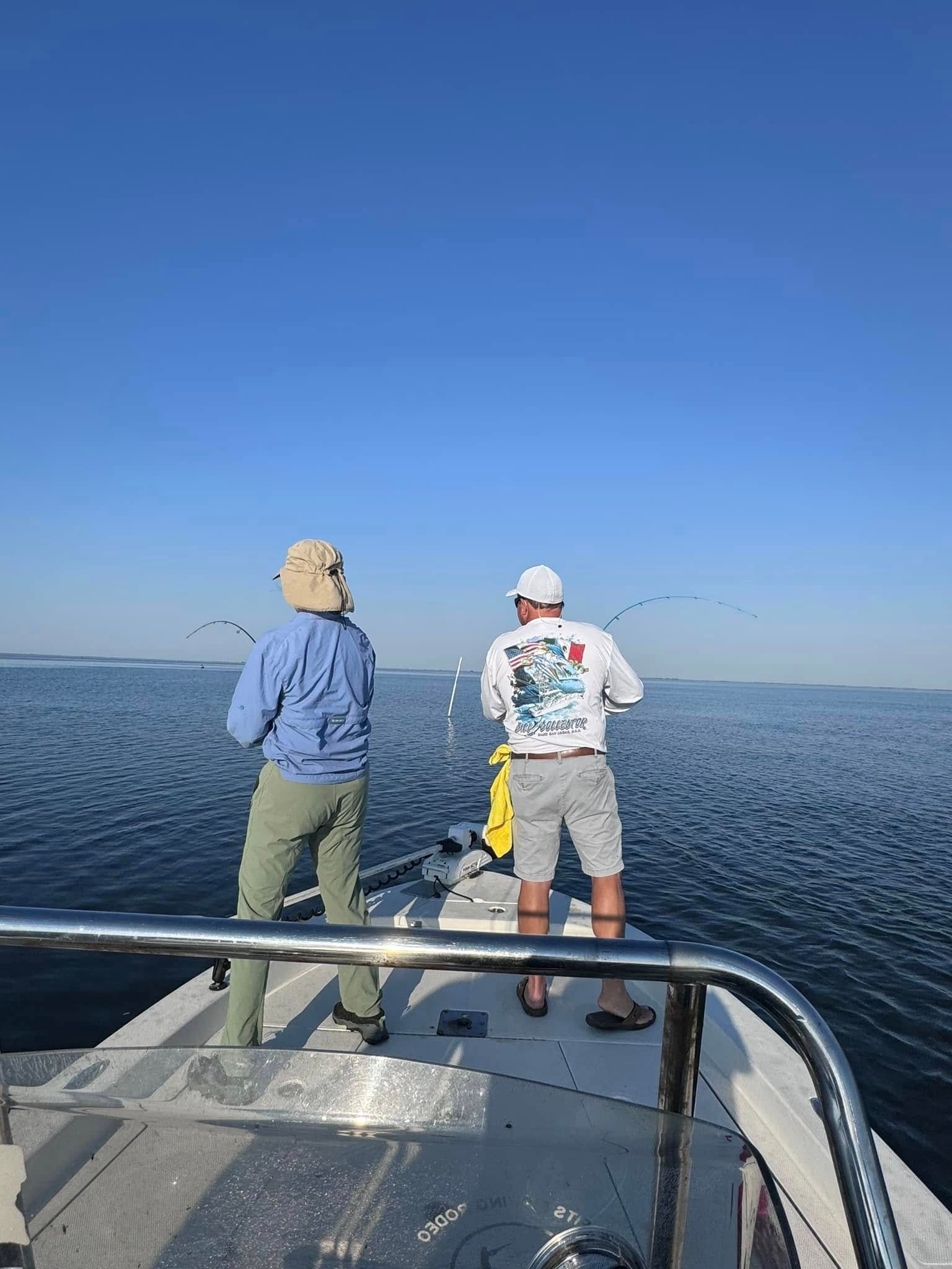 Two men are fishing on a boat in the ocean.