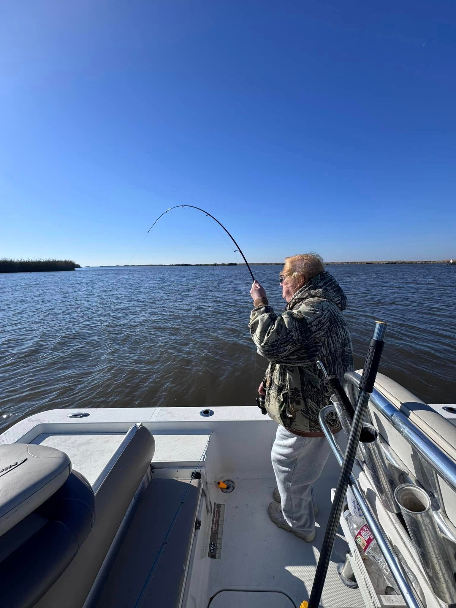 Two people are fishing on a boat in the ocean.