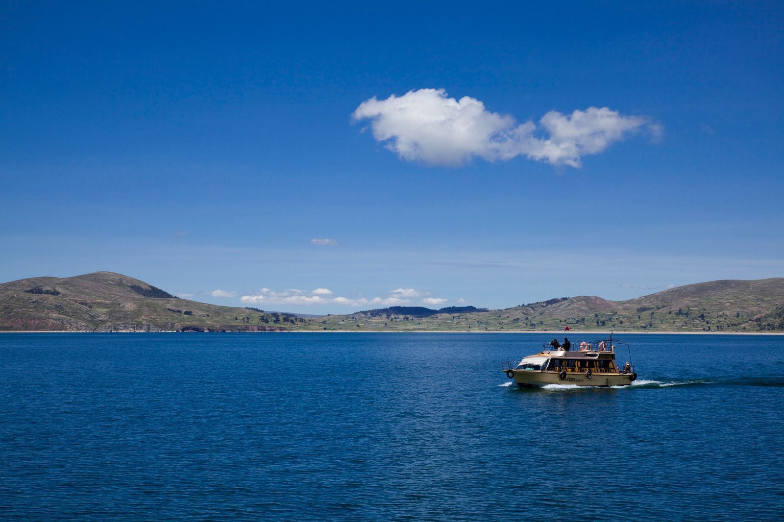 A man and a woman are holding a fish on a boat.