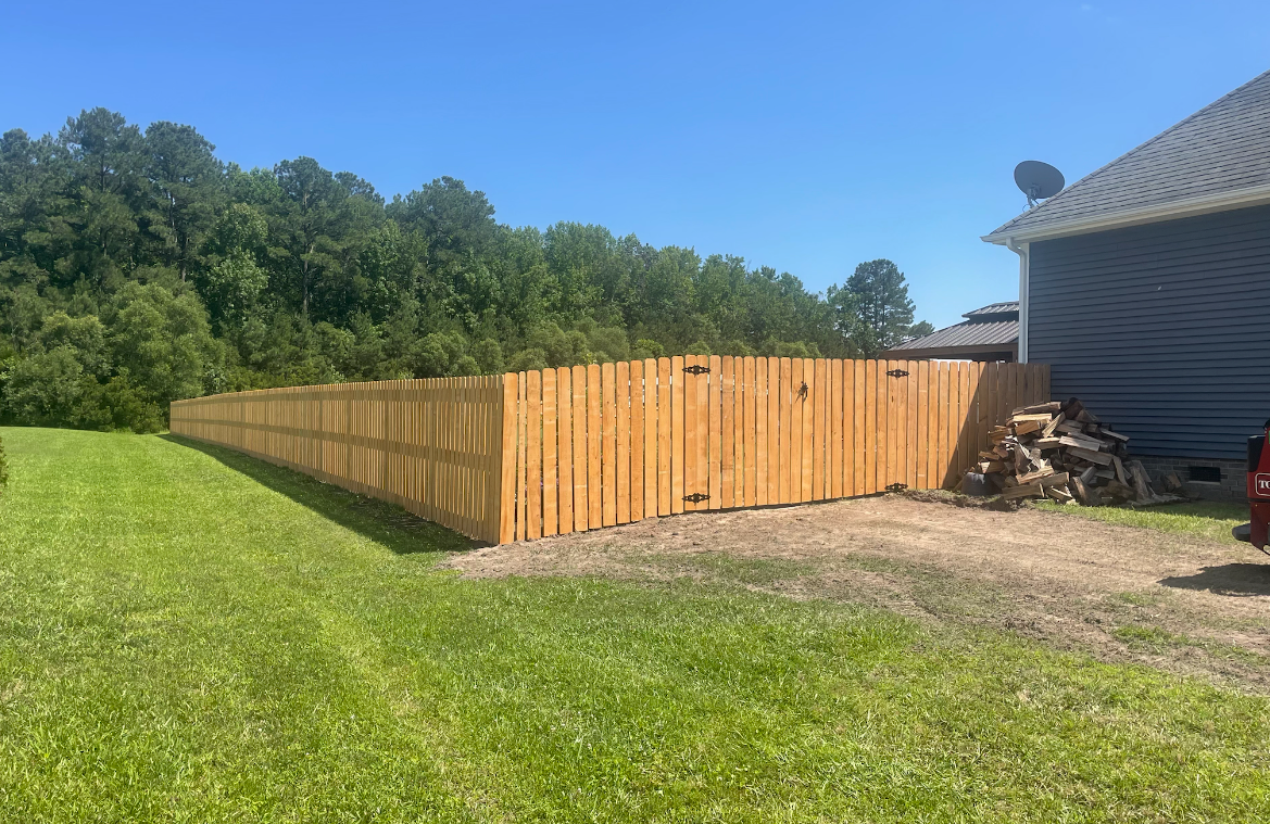 A white picket fence with pink roses growing on it.