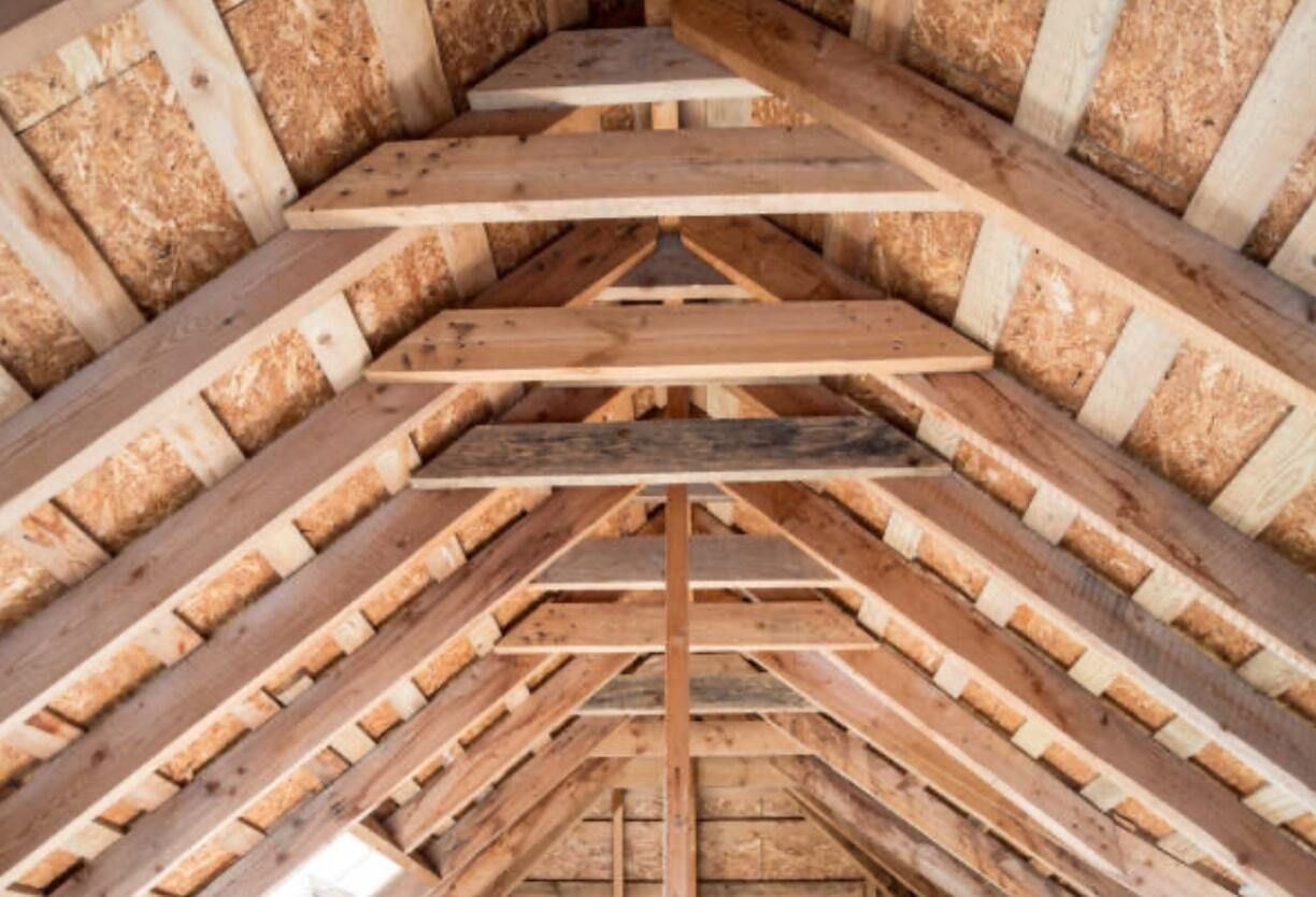 Charpente de toit en bois avec poutres apparentes et revêtement en panneaux OSB.