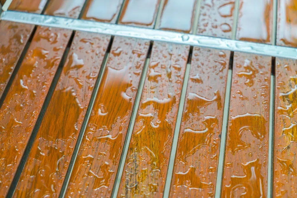 Wooden slats with raindrops, a close-up detail.