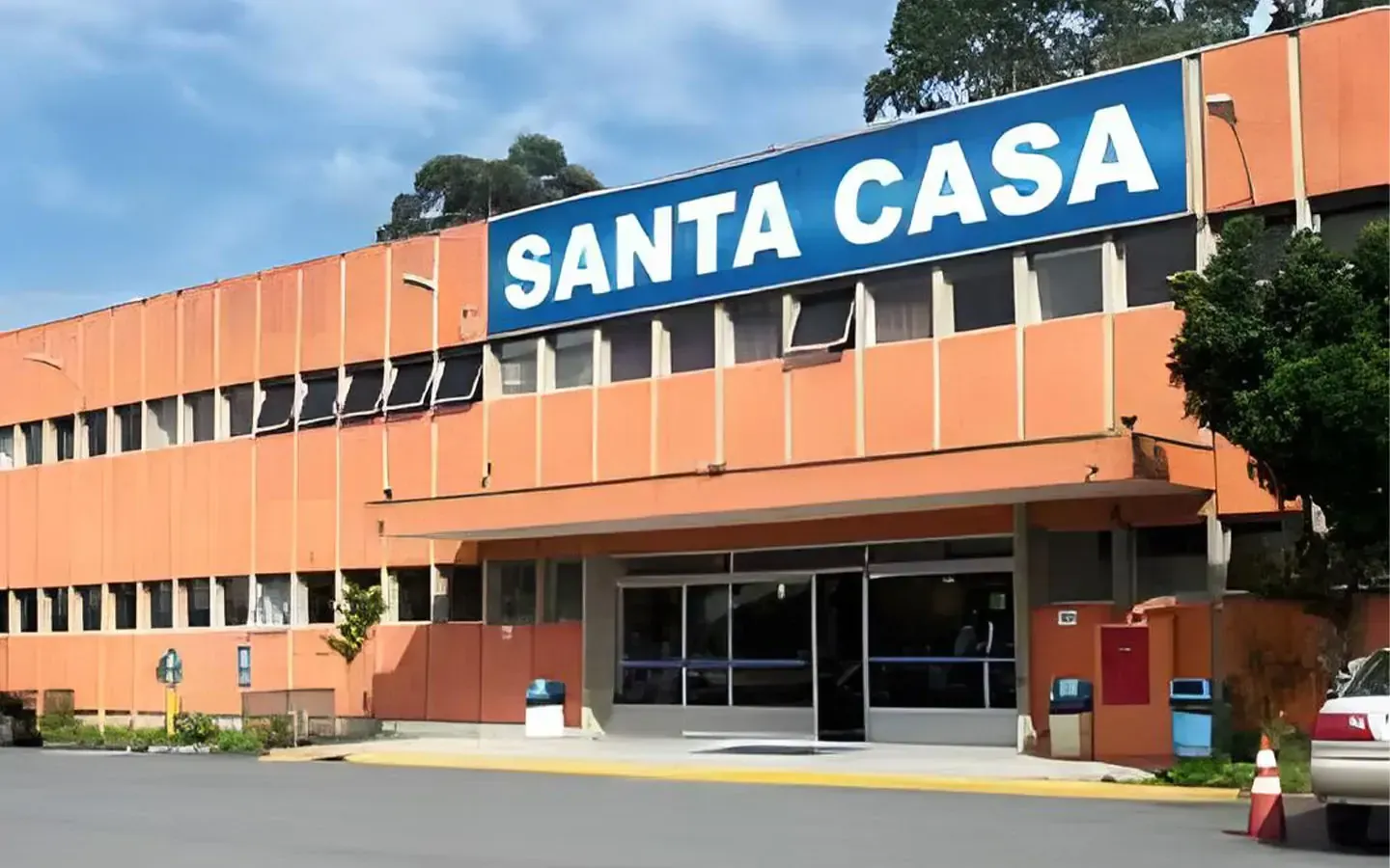 Um grande edifício laranja com uma placa azul que diz santa casa
