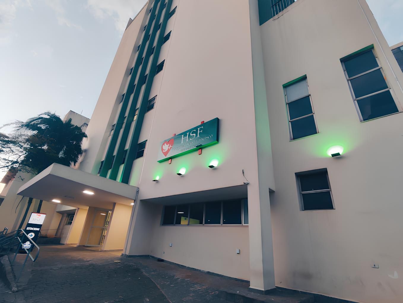 Um grande edifício branco com luzes verdes na lateral