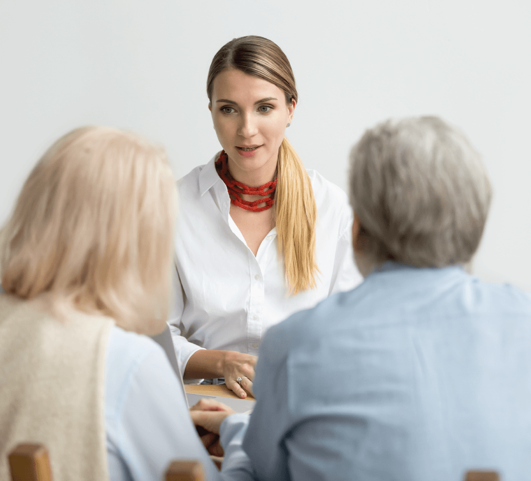corretora de planos conversando com casal de idosos