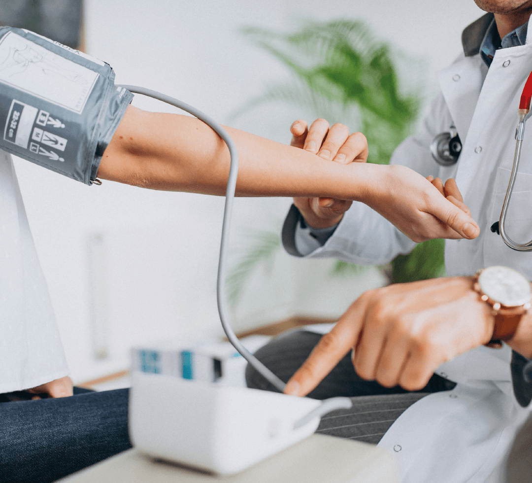 Profissional da saúde aferindo a pressão arterial de paciente, representando atendimento clínico.