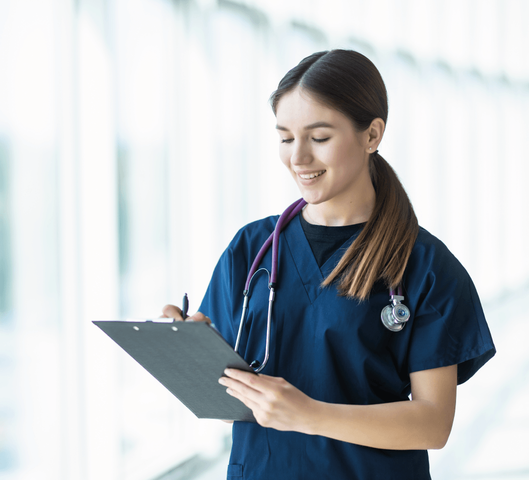 médica com estetoscópio e prancheta sorrindo enquanto escreve