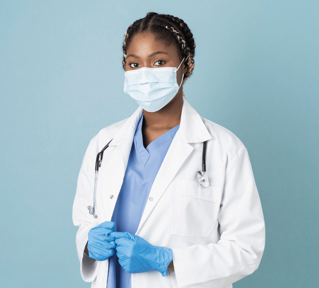 Médica negra com jaleco e máscara de proteção, em fundo azul, transmitindo segurança e cuidado.