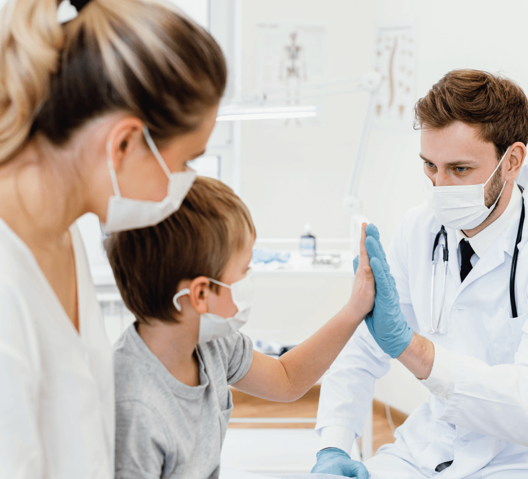Um médico está dando um high five em uma criança enquanto usa uma máscara