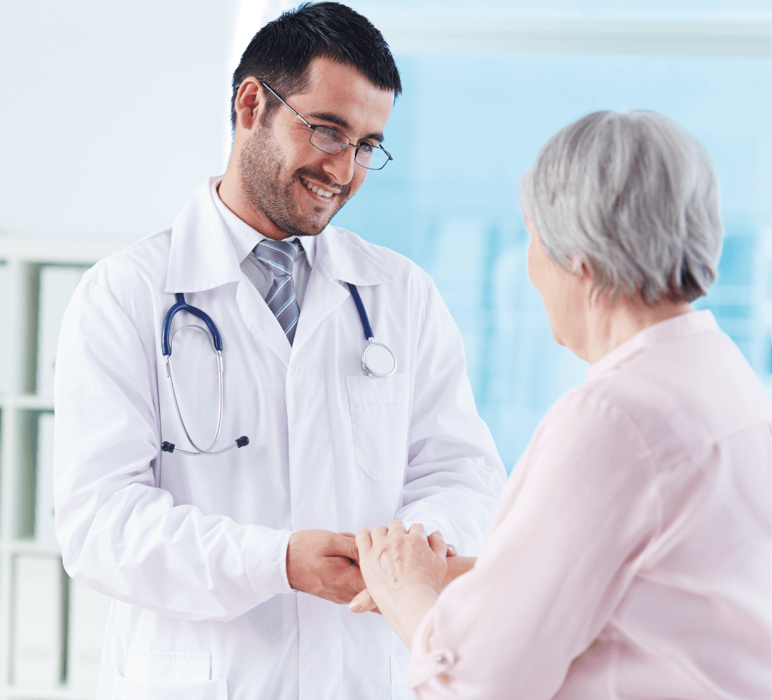 Médico sorridente conversando com paciente idosa, representando atendimento acolhedor em planos de saúde.