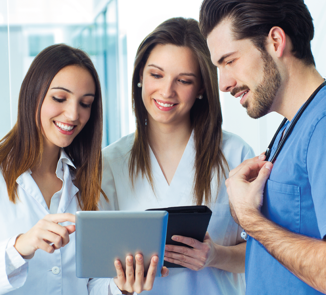 Um homem e duas mulheres estão olhando para um tablet juntos