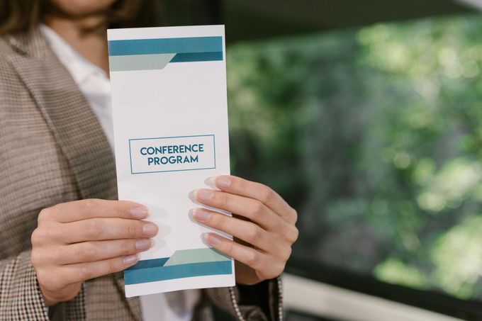 A woman is holding a brochure in her hands.