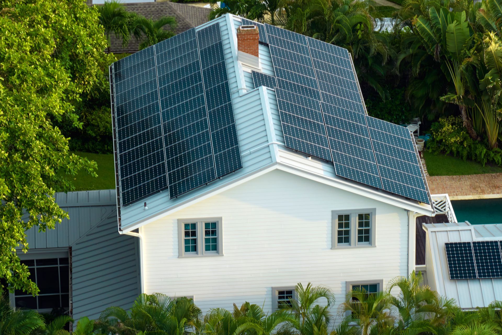 An aerial view of a house with solar panels on the roof.