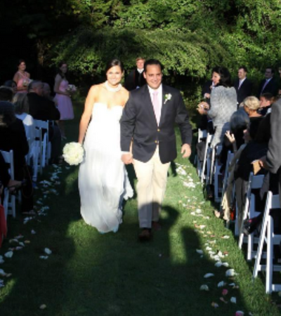 Bride and groom walking down an outdoor aisle at a wedding ceremony