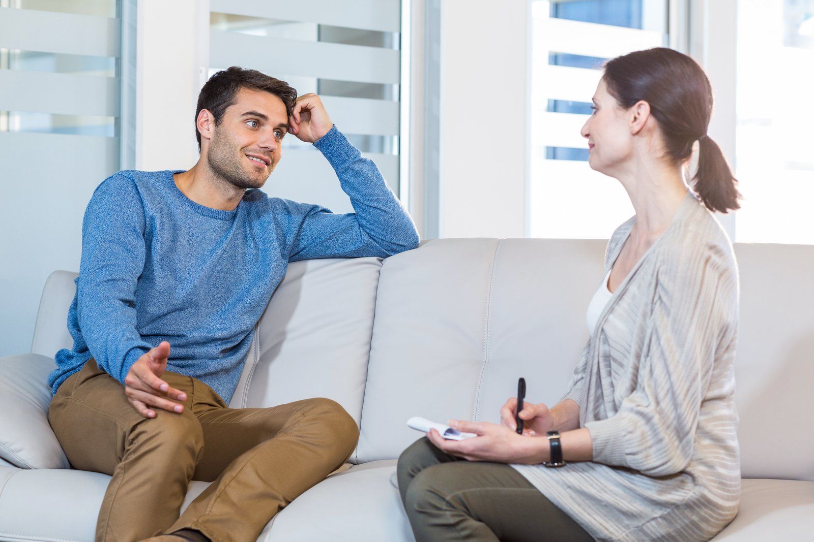 man talking to a woman on a couch