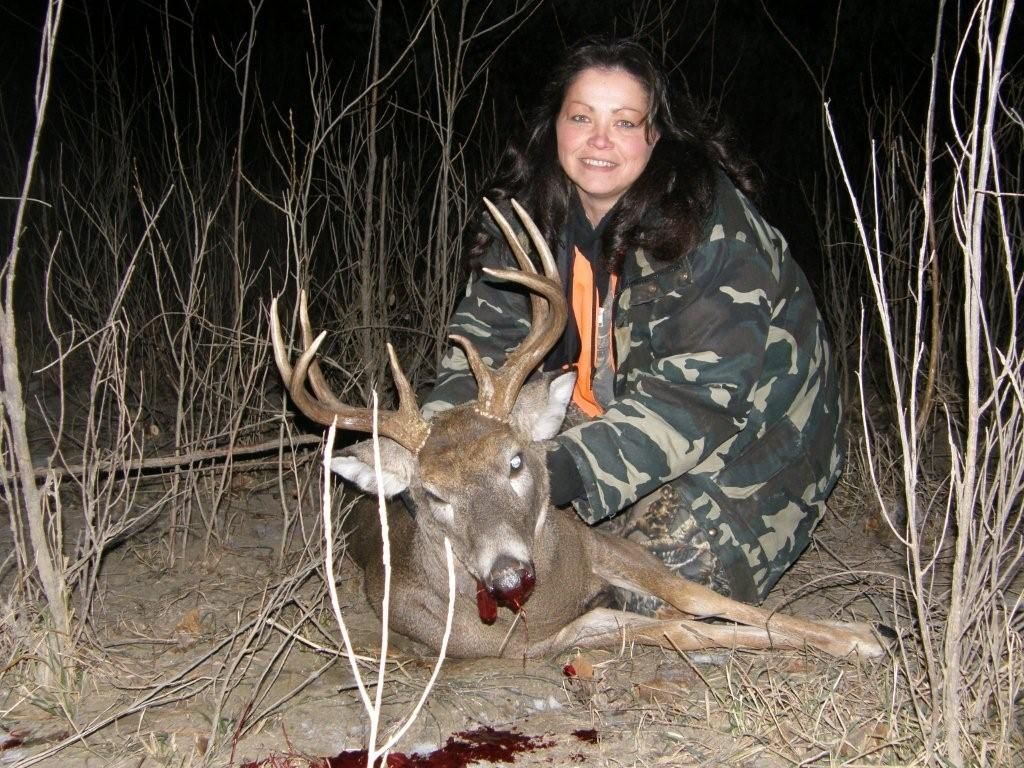 A woman posing with a dead deer