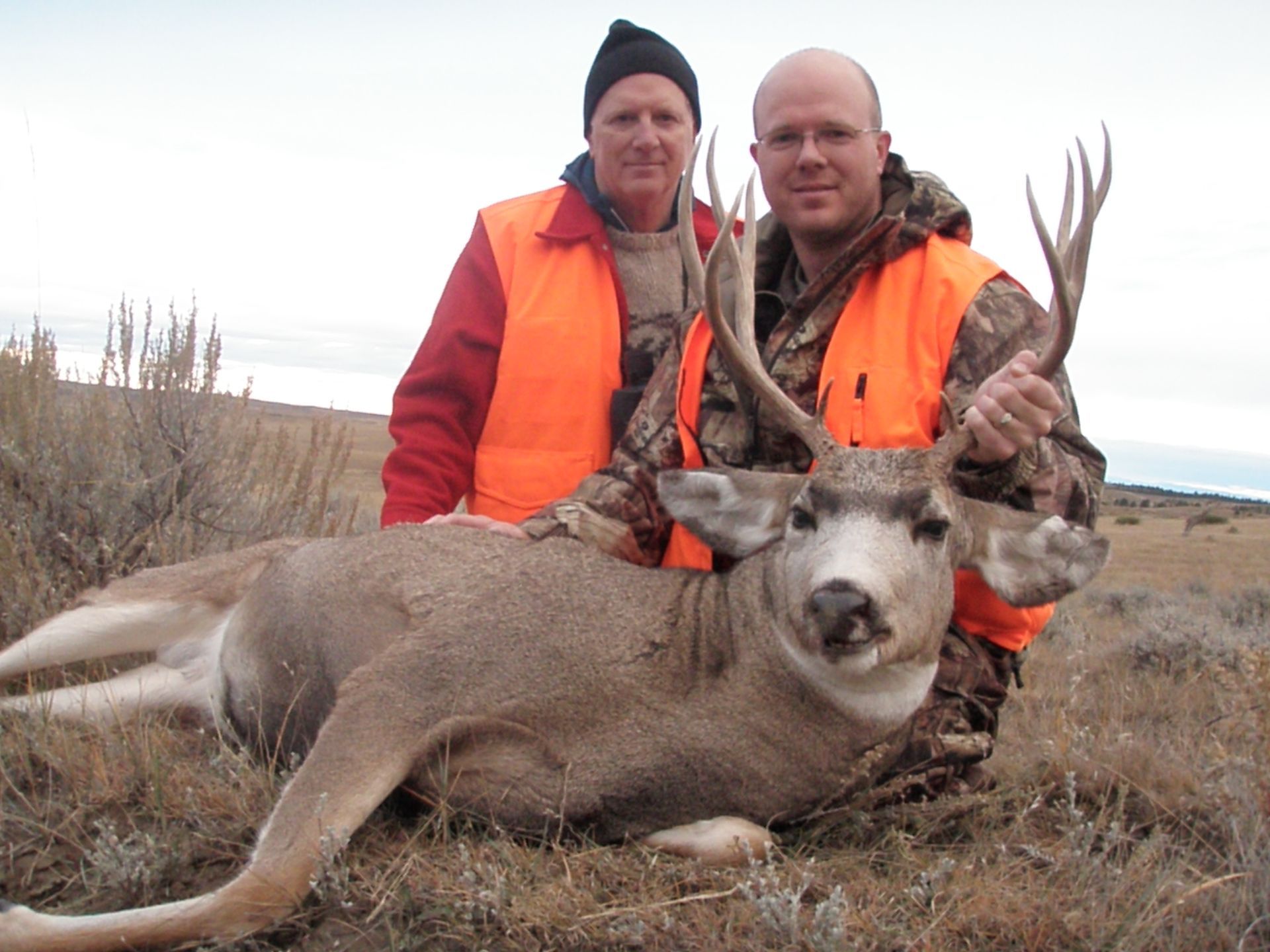 Two men posing with a dead deer