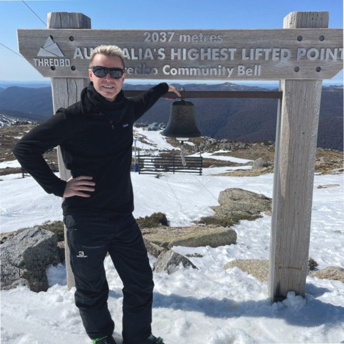 A Man Standing In Front Of A Sign With A Bell - Entrepreneur on the Gold Coast, QLD