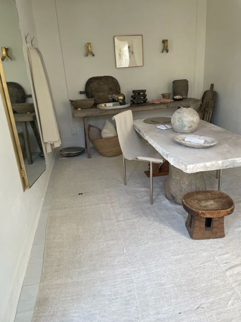 Dining room with stone table, wooden stool, and neutral decor.