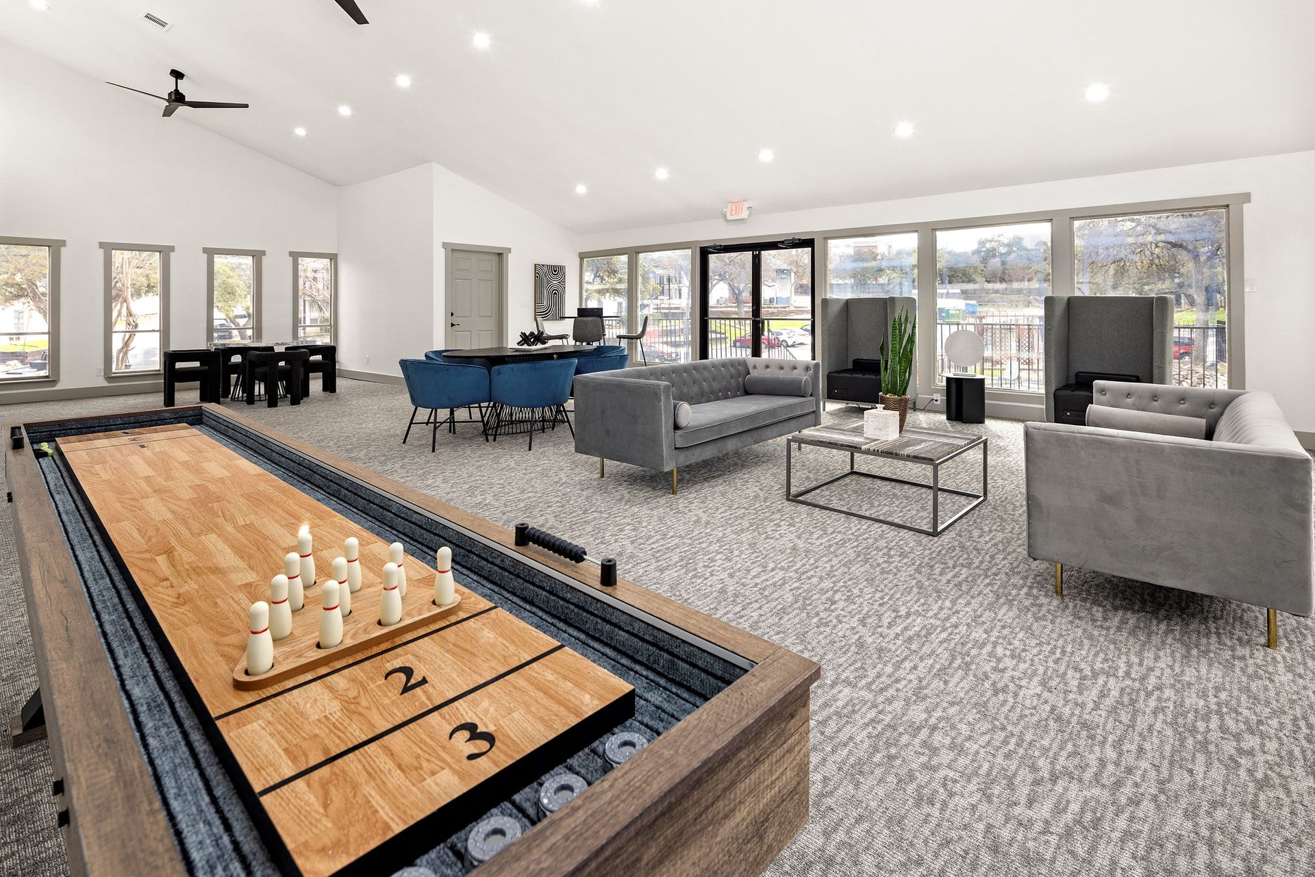 A clubhouse room with a pool table, couch, table, and chairs.