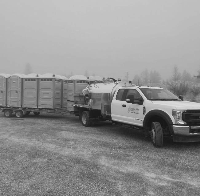 A black and white photo of a truck with a trailer attached to it.