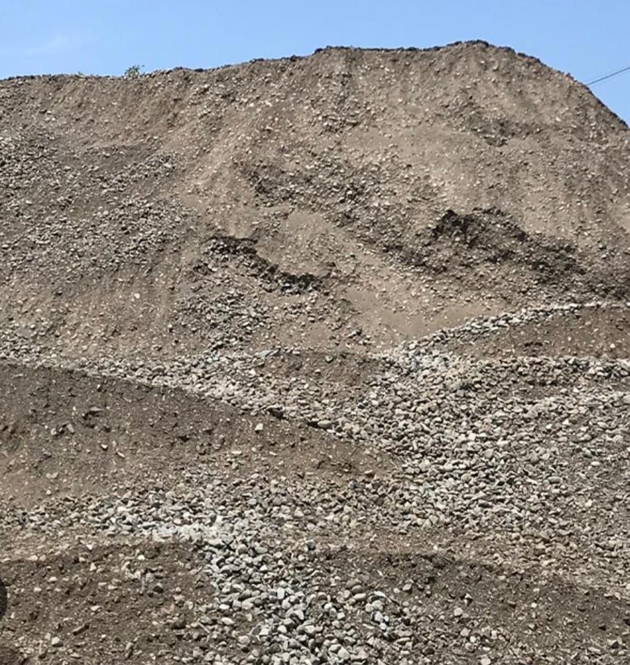 Montón de grava y tierra contra un cielo azul.