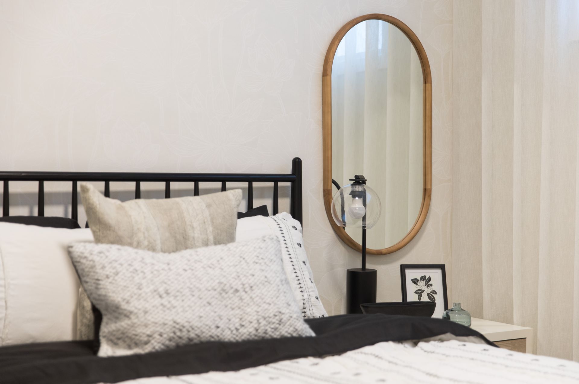 A bedroom with a bed and a mirror on the wall.