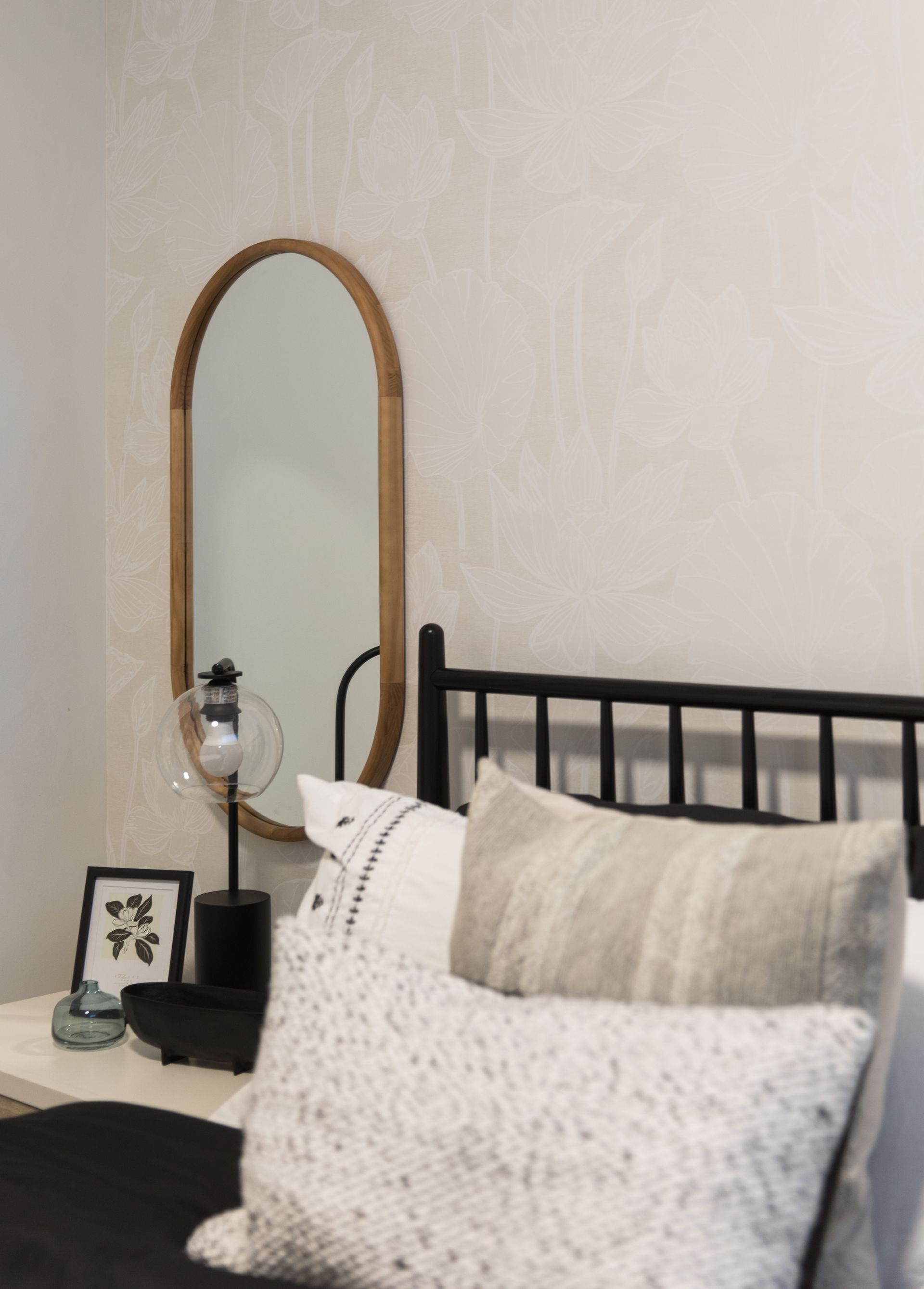 A bedroom with a bed and a mirror on the wall