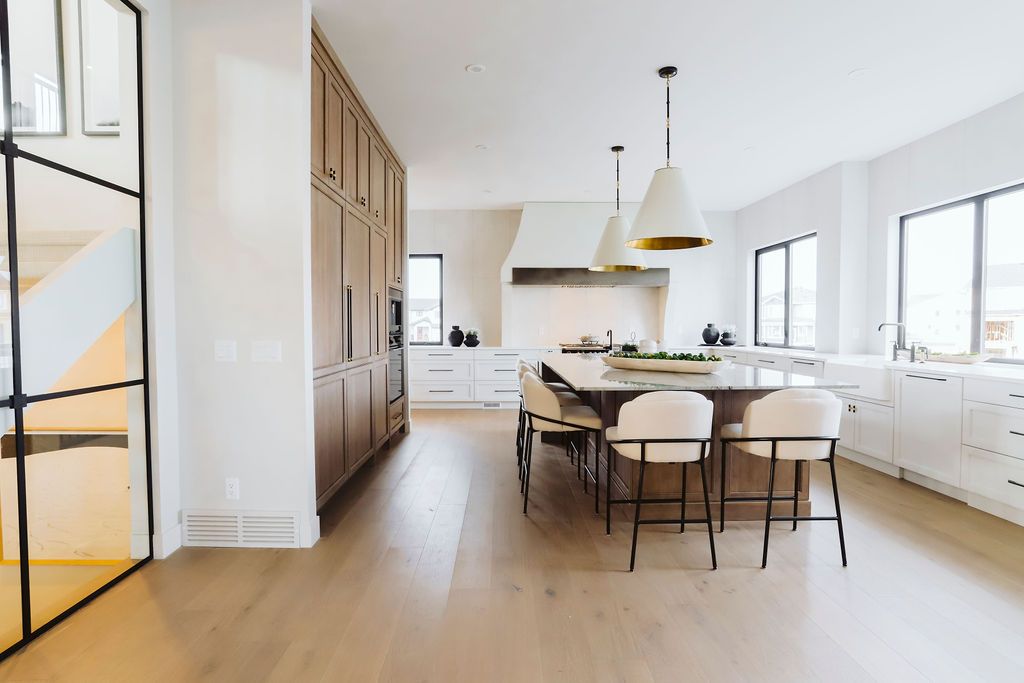 A large kitchen with a large island in the middle and lots of windows.
