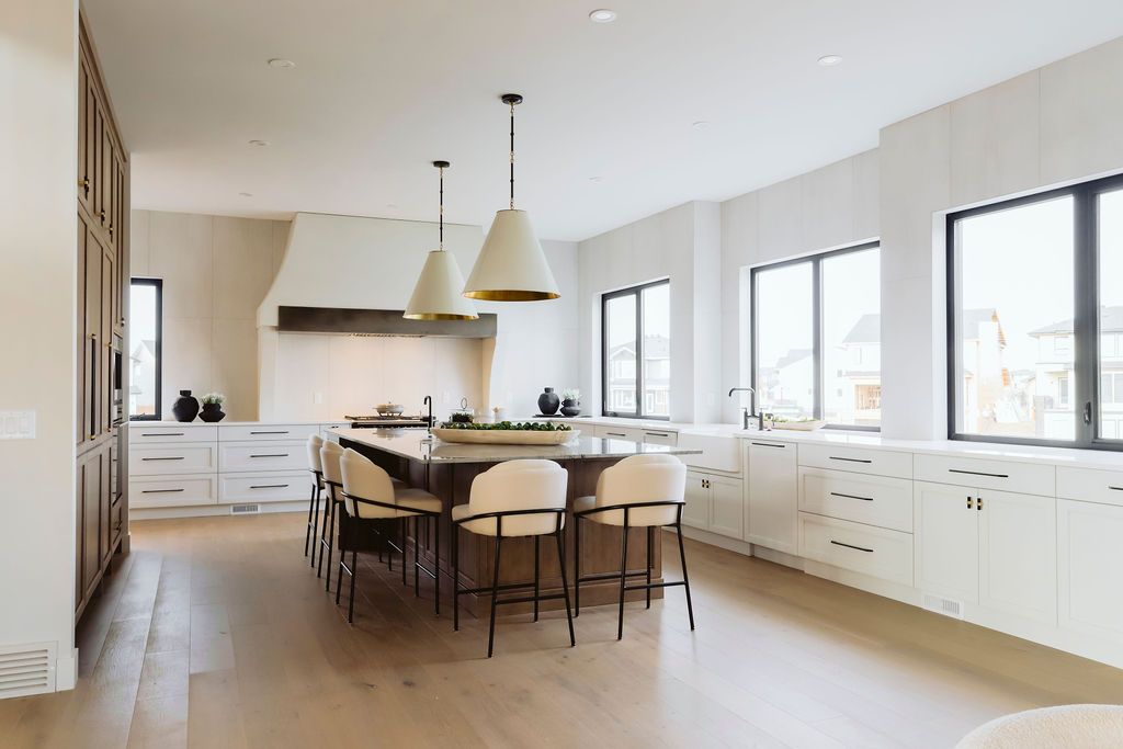 A large kitchen with a large island and lots of windows.