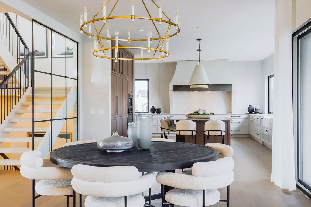A dining room with a table and chairs and a chandelier hanging from the ceiling.