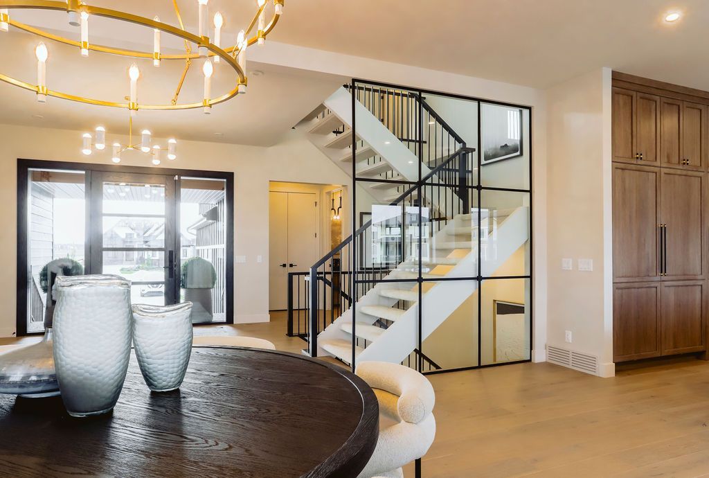 A living room with a table and chairs and a staircase in the background.