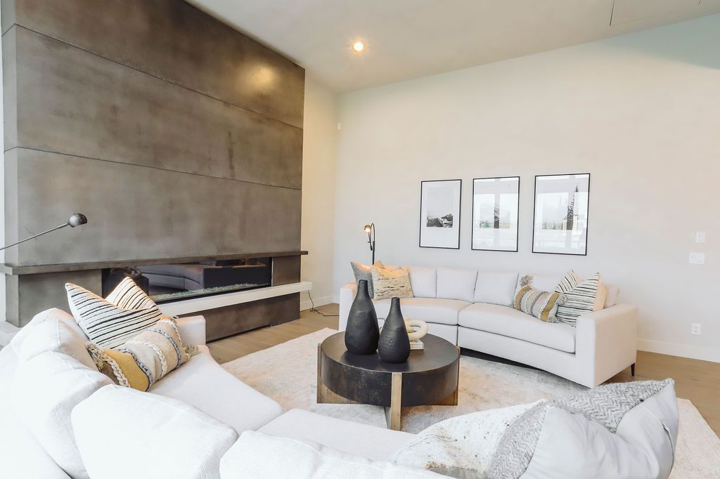 A living room with white furniture and a fireplace