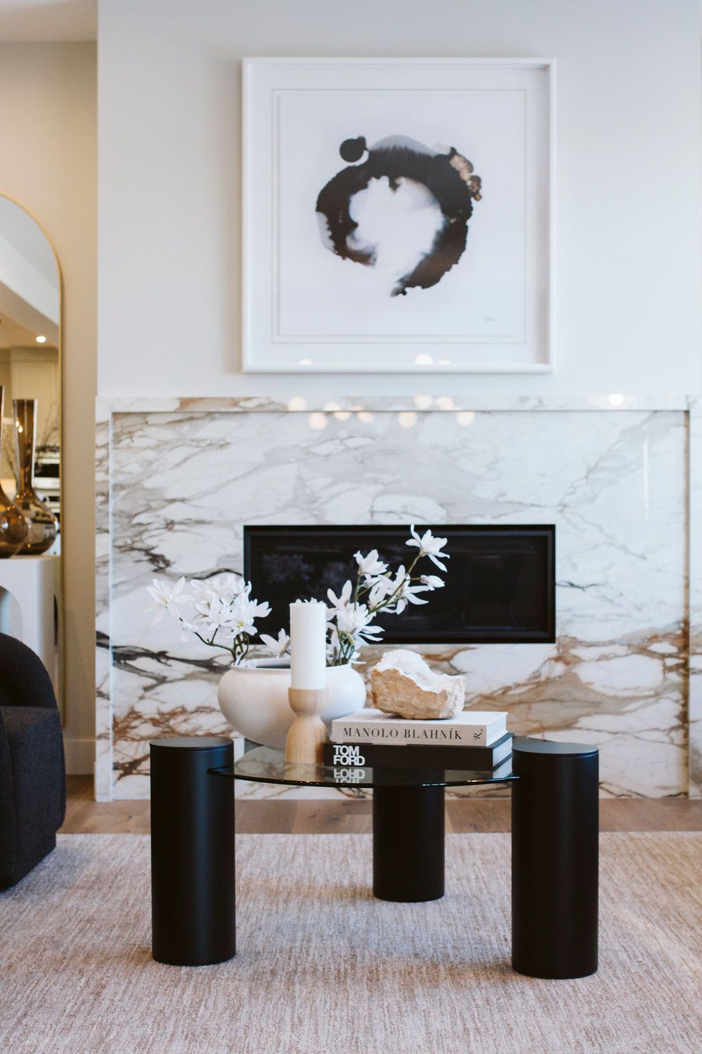 A living room with a fireplace and a glass coffee table