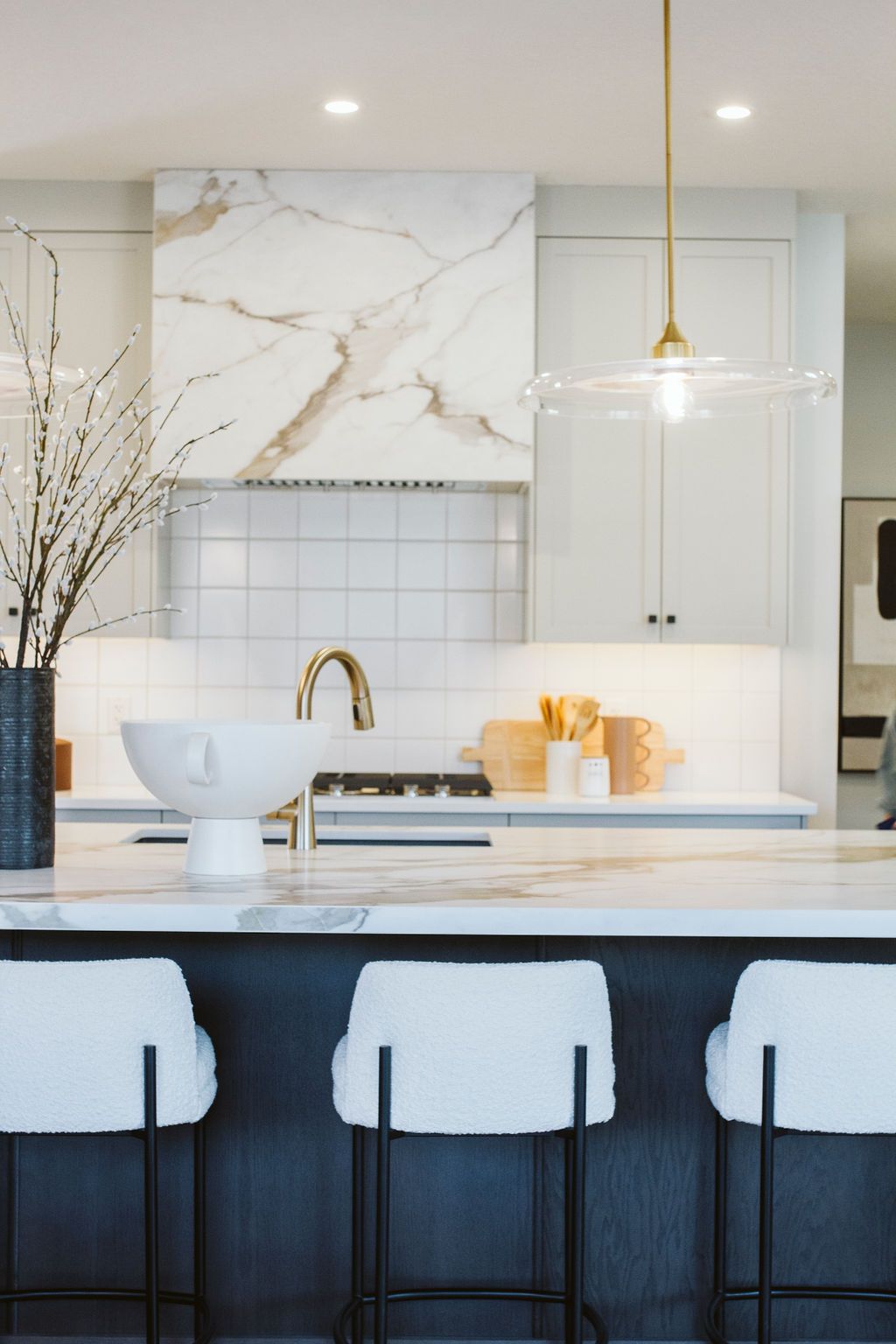 A kitchen with a large island and three stools