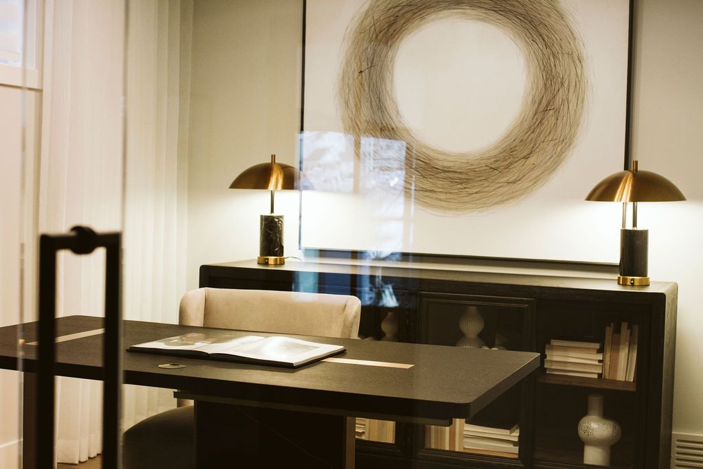 A room with a table and chairs and a painting on the wall