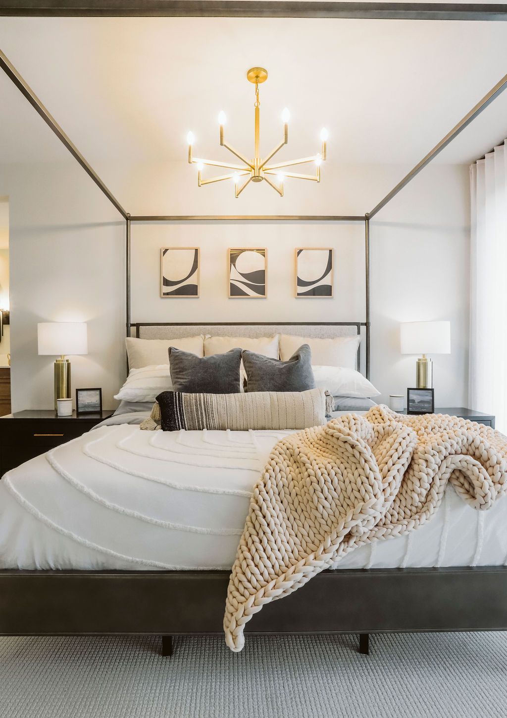 A bedroom with a canopy bed and a chandelier hanging from the ceiling.