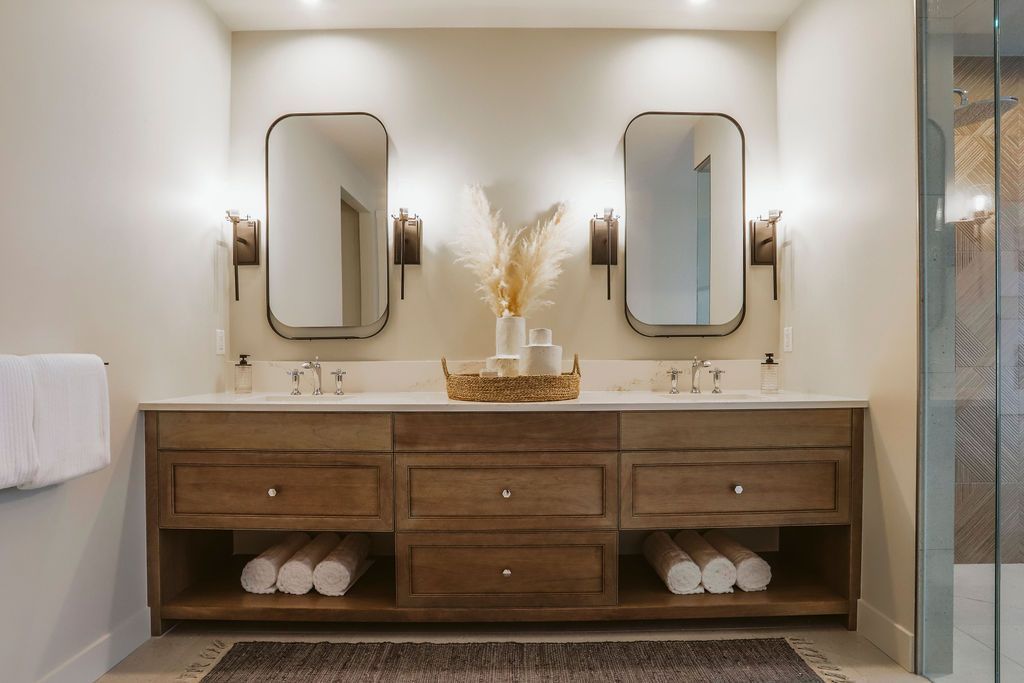 A bathroom with two sinks and two mirrors.