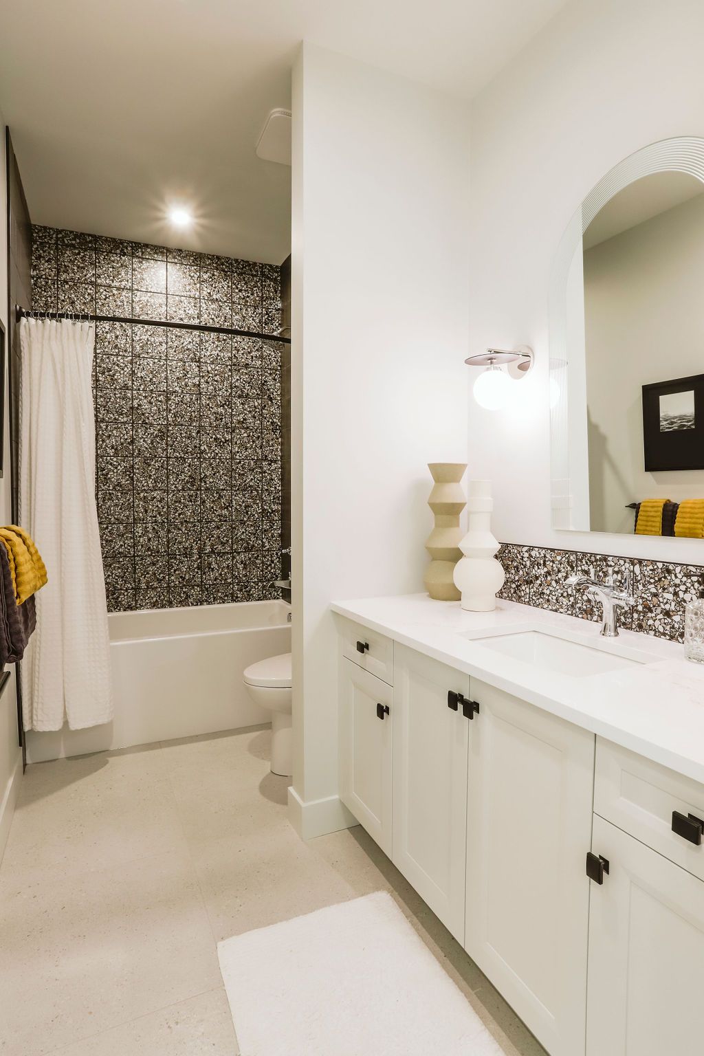A bathroom with a sink , toilet , bathtub and mirror.