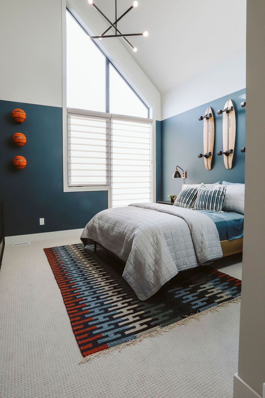 A bedroom with a bed , rug and surfboards on the wall