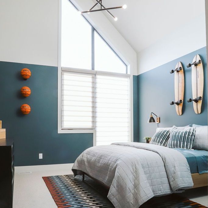 A bedroom with a bed and skateboards on the wall