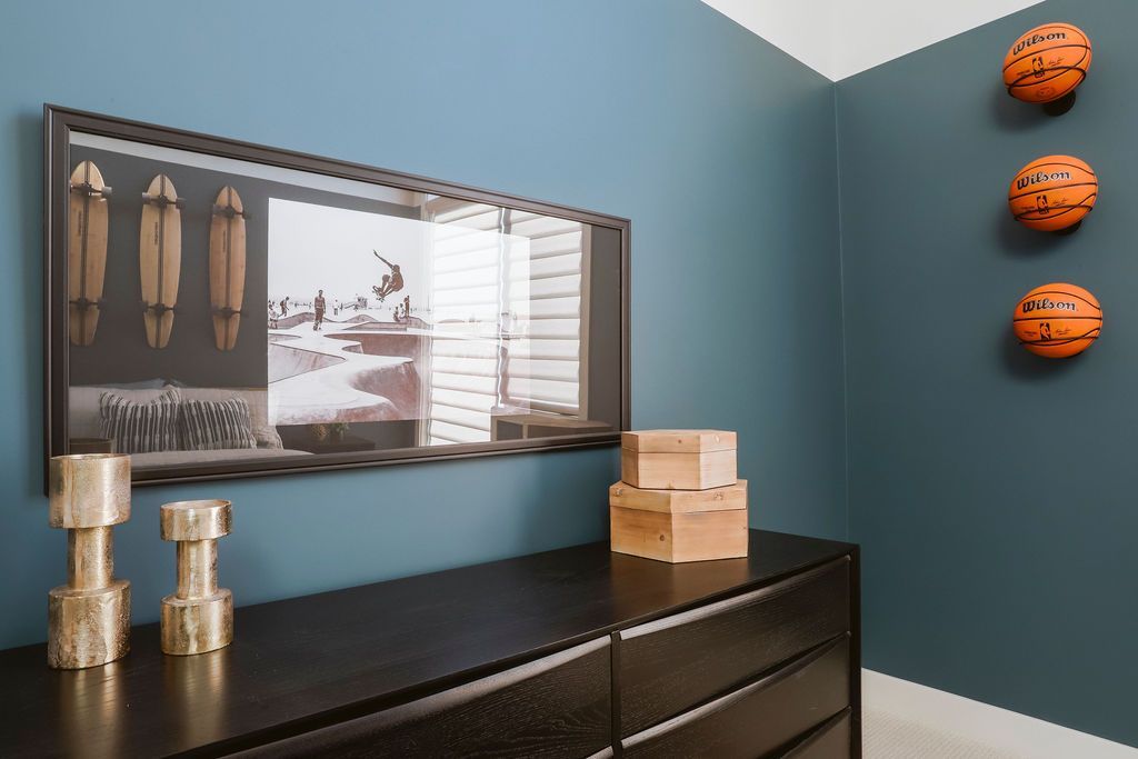 There are three basketballs hanging on the wall above the dresser.