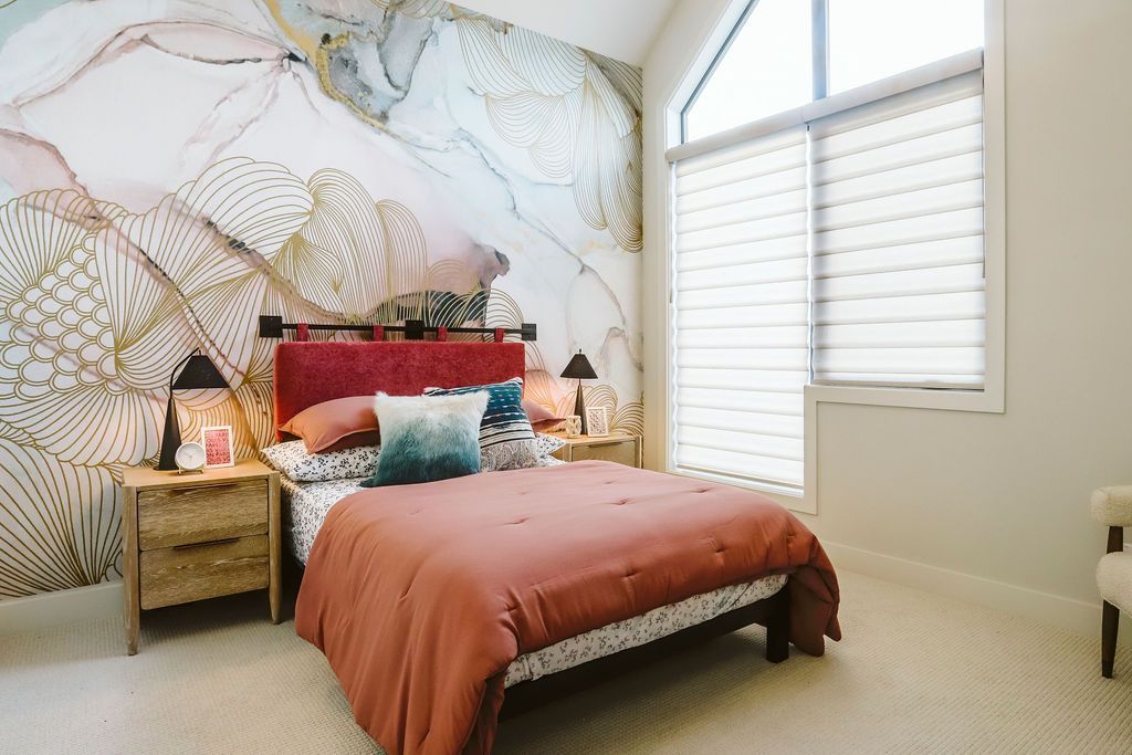 A bedroom with a bed , nightstands , and a large window.