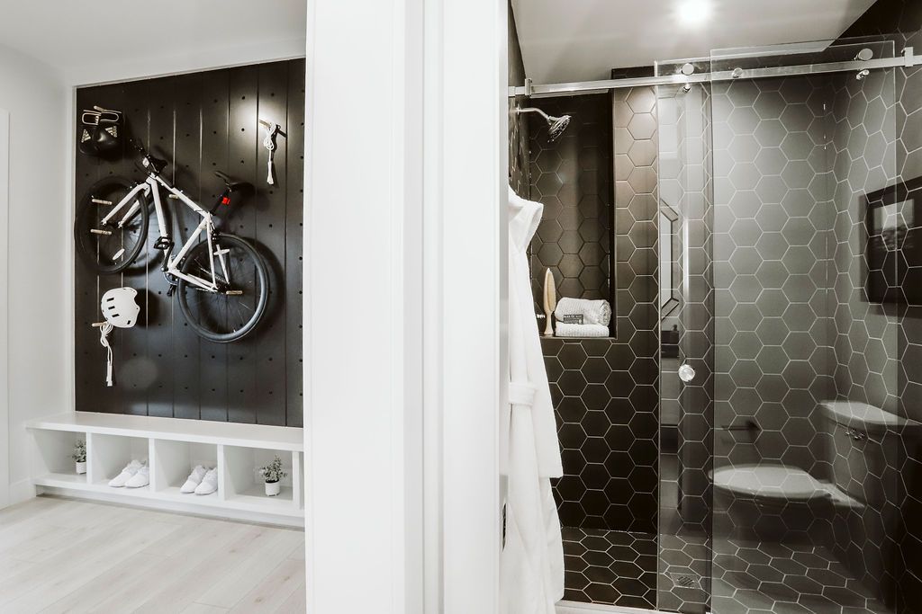 A bicycle is hanging on a wall next to a bathroom.