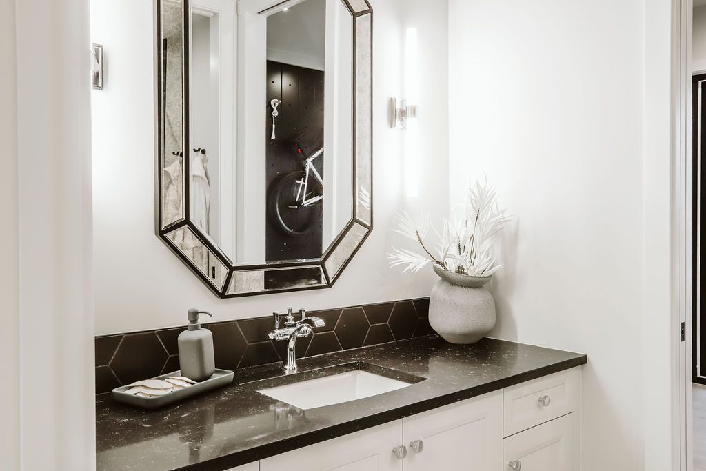 A bathroom with a sink , mirror , and cabinets.