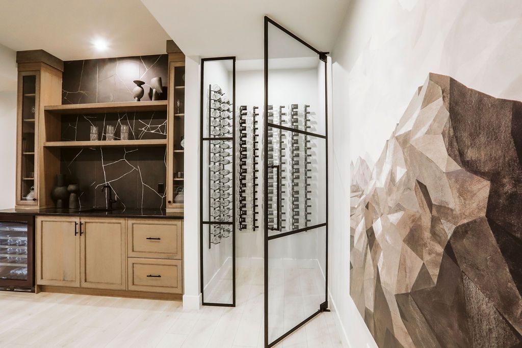A wine cellar with a glass door and a painting on the wall.