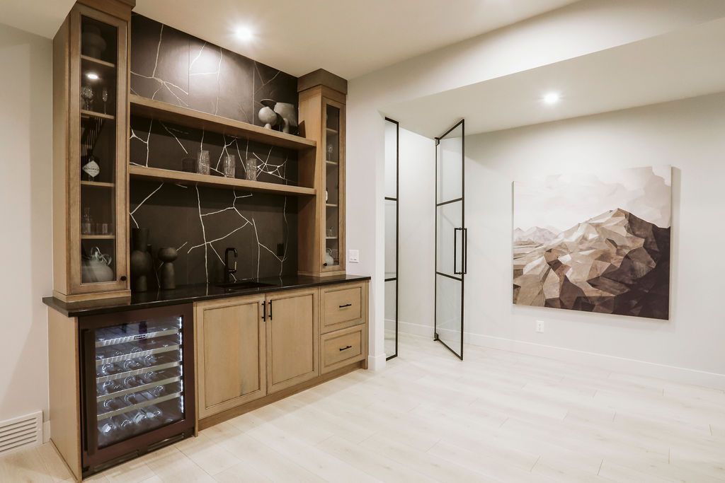 A home bar with a wine cooler and a painting on the wall.