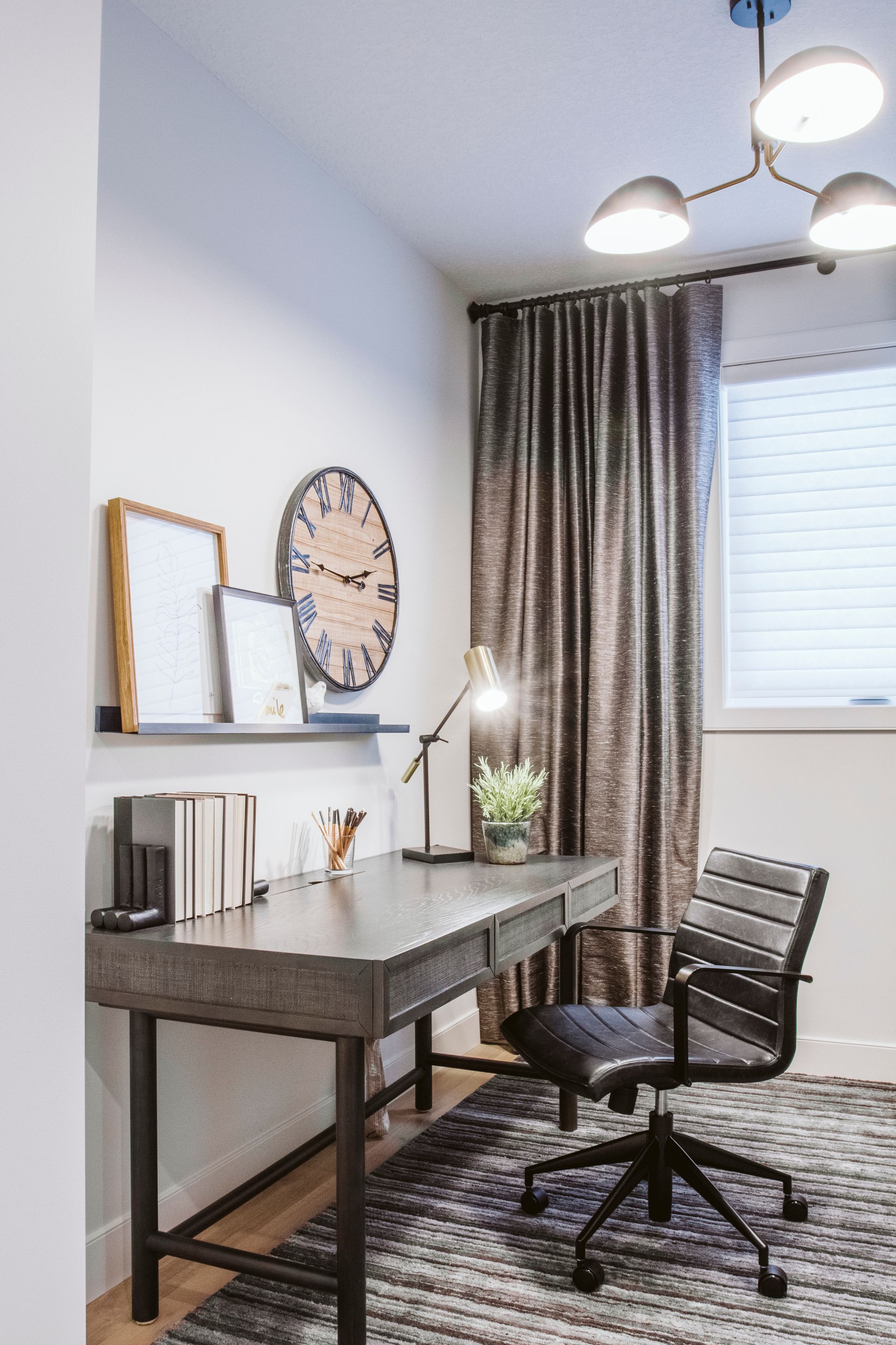 A home office with a desk and chair and a clock on the wall.