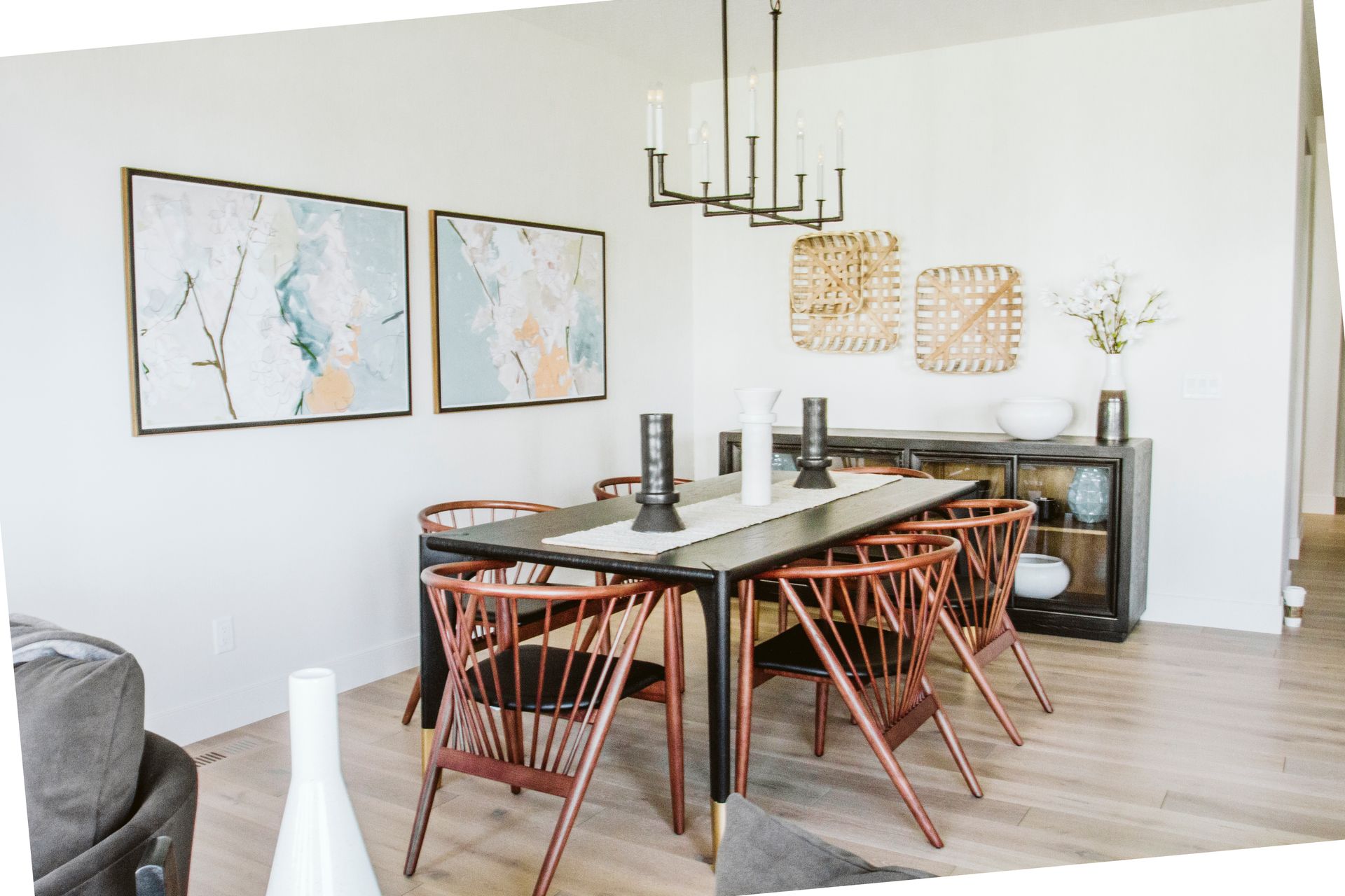 A dining room with a table and chairs and a chandelier hanging from the ceiling.